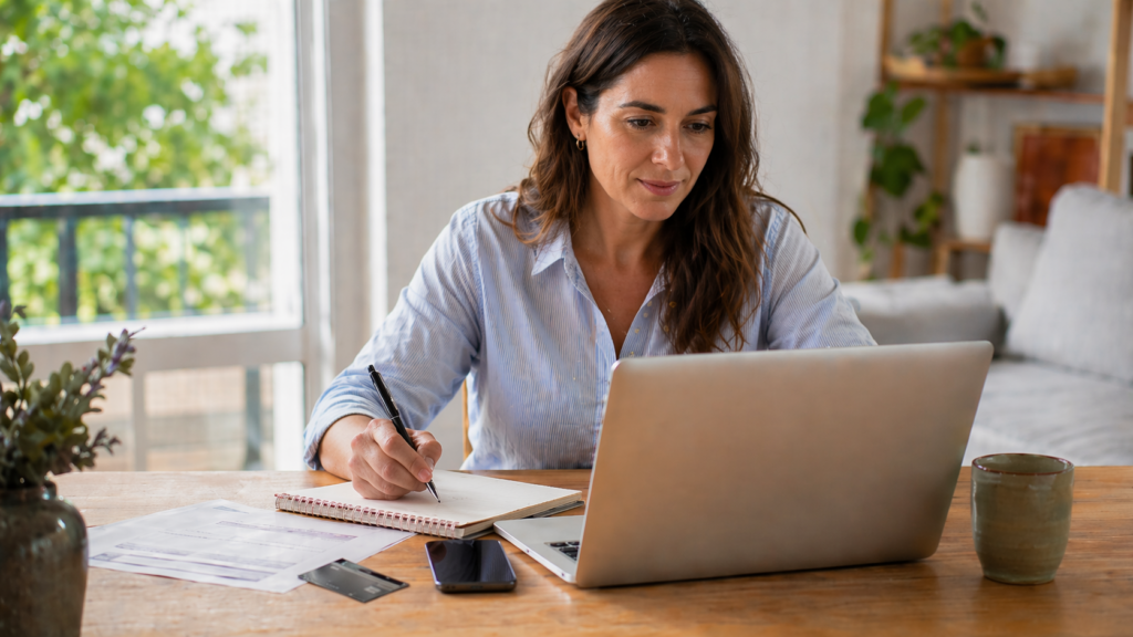 Persona revisando costos, promociones y condiciones de una tarjeta de crédito en una mesa de trabajo.